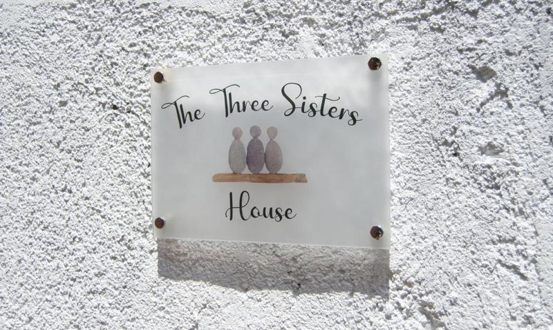 The Three Sisters House sign with its three-pebble emblem